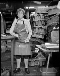 Czarno-biała fotografia. Kobieta pracująca w warsztacie.