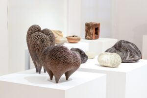 Ceramiczne figury w kształcie chropowatych kul zawężających się do podstawy autorstwa Hanny Miadzvedzevej