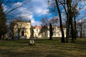 rzeźba kamienna na łące na tle pałacu