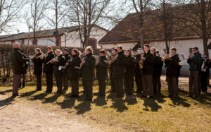 orkiestra dęta przed budynkiem w Będominie w czasie gry, słoneczna pogoda