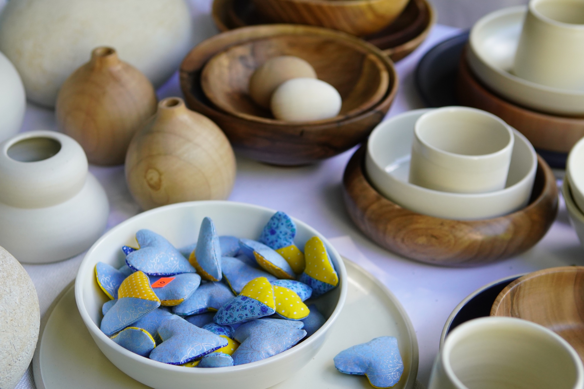 naczynia ceramiczne i drewniane wypełnione gadżetami
