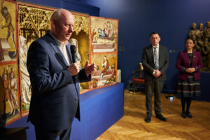 w sali z gotycką rzeźbą przemawia były dyrektor Wojciech Bonisławski